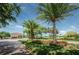 Landscaped community entrance with a guard house, palm trees, and flowering plants under a clear sky at 2775 Kipps Colony S Dr # 105, Gulfport, FL 33707