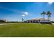View of the golf course clubhouse, a manicured lawn, and a clear blue sky, perfect for a relaxing round of golf at 2775 Kipps Colony S Dr # 105, Gulfport, FL 33707