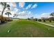 Scenic view of the golf course with a meandering cart path, lush green grass, and tropical foliage under a blue sky at 2775 Kipps Colony S Dr # 105, Gulfport, FL 33707