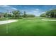 Beautiful golf course view with lush green grass, mature trees, sand trap, and blue skies at 2775 Kipps Colony S Dr # 105, Gulfport, FL 33707
