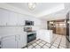 Modern kitchen featuring stainless steel appliances and white cabinets with checkered floors at 2775 Kipps Colony S Dr # 105, Gulfport, FL 33707