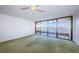 Bright living area features green carpet and access to a waterfront balcony at 2775 Kipps Colony S Dr # 105, Gulfport, FL 33707
