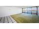Spacious living area with green carpet and sliding doors to the waterfront balcony at 2775 Kipps Colony S Dr # 105, Gulfport, FL 33707