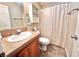 Bathroom with a vanity, toilet, shower with white curtain, and a tiled floor at 37544 Corey Lewis Ave, Zephyrhills, FL 33541