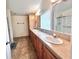 Bathroom with double sinks, ample counter space, wood cabinets and tile flooring at 37544 Corey Lewis Ave, Zephyrhills, FL 33541