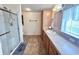 Bathroom features a glass enclosed shower, wood cabinets, and tile flooring at 37544 Corey Lewis Ave, Zephyrhills, FL 33541