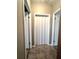 Neutral hallway featuring wood look tiling and multiple doorway entrances at 37544 Corey Lewis Ave, Zephyrhills, FL 33541