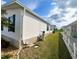Exterior side view of home featuring white siding, green shutters, and well-kept lawn at 37544 Corey Lewis Ave, Zephyrhills, FL 33541