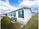 Exterior side view of home with white siding, green shutters, and an AC unit at 37544 Corey Lewis Ave, Zephyrhills, FL 33541