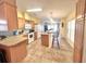 Inviting kitchen featuring oak cabinets, white appliances, and a breakfast bar with seating at 37544 Corey Lewis Ave, Zephyrhills, FL 33541