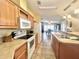 Bright kitchen with wood cabinets, stainless steel sink, and a view into the dining area at 37544 Corey Lewis Ave, Zephyrhills, FL 33541
