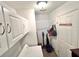 Functional laundry area with storage cabinets, hanging rack, and convenient cleaning supplies storage at 37544 Corey Lewis Ave, Zephyrhills, FL 33541
