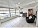 A sunroom with tile floors, a ceiling fan, and a seating area offering plenty of sunlight at 37544 Corey Lewis Ave, Zephyrhills, FL 33541