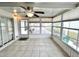 Enclosed sunroom with tile flooring, ceiling fan, and plenty of natural light through large windows at 37544 Corey Lewis Ave, Zephyrhills, FL 33541