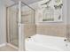 Bright bathroom features a shower with glass door next to a tiled tub and an elegant art piece at 777 N Ashley Dr # 1614, Tampa, FL 33602