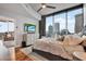 Bright bedroom with hardwood flooring, large windows showcasing city views, and a modern dresser at 777 N Ashley Dr # 1614, Tampa, FL 33602