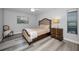 Cozy bedroom with neutral tones, wood-look flooring, and a comfortable upholstered bed at 9204 Golf View Dr, New Port Richey, FL 34655