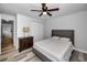 Bright bedroom with a ceiling fan, dresser and view into the living area at 9204 Golf View Dr, New Port Richey, FL 34655