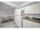 Bright kitchen featuring white appliances, granite countertops, and a view of the adjacent dining area at 9204 Golf View Dr, New Port Richey, FL 34655