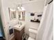 Bathroom features a modern sink, stylish fixtures, decorative mirror, and a toilet at 100 Waverly Way # 302, Clearwater, FL 33756