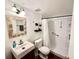 Well-lit bathroom with white sink, leaf-themed mirror, toilet, and walk-in shower with safety bars at 100 Waverly Way # 302, Clearwater, FL 33756