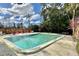 Community pool surrounded by lounge chairs, set against a backdrop of lush trees and blue skies at 100 Waverly Way # 302, Clearwater, FL 33756