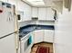 Bright kitchen with white cabinets, appliances, and blue countertops at 100 Waverly Way # 302, Clearwater, FL 33756
