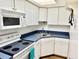 Functional kitchen with white cabinetry, efficient appliances, and ample countertop space at 100 Waverly Way # 302, Clearwater, FL 33756