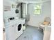 Bright laundry room with washing machines, a sink, and a comfortable seating area at 100 Waverly Way # 302, Clearwater, FL 33756