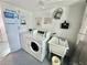 A community laundry room with a washer and dryer, featuring tile floors, a utility sink, and a window at 100 Waverly Way # 302, Clearwater, FL 33756