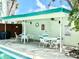 Outdoor seating area by the pool with comfortable chairs and tables under a covered patio at 100 Waverly Way # 302, Clearwater, FL 33756