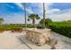 Outdoor grilling area with a built-in grill, picnic table, and palm trees overlooking the water at 1011 Sonata Ln, Apollo Beach, FL 33572