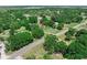 A high aerial view of a charming property nestled among mature trees, with a long driveway at 12526 Spottswood Dr, Riverview, FL 33579