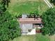 Aerial view of home surrounded by mature trees, with a gravel landscape and grassy lawn at 12526 Spottswood Dr, Riverview, FL 33579