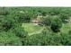 Aerial view of home surrounded by mature trees and a large green lawn at 12526 Spottswood Dr, Riverview, FL 33579