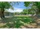 Large backyard featuring green grass, mature trees, and a glimpse of the home in the distance at 12526 Spottswood Dr, Riverview, FL 33579