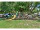 Backyard playset with slides and swings surrounded by mature trees and ample space for play at 12526 Spottswood Dr, Riverview, FL 33579