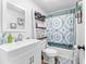 Bright bathroom featuring a white vanity, decorative shower curtain, and ladder shelf for added storage space at 12526 Spottswood Dr, Riverview, FL 33579