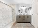Bright modern bathroom with wood floors, white cabinets, dual sinks, and a shower at 12526 Spottswood Dr, Riverview, FL 33579