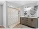 Modern bathroom features dual sinks, walk in shower, wood floors, and decorative mirrors at 12526 Spottswood Dr, Riverview, FL 33579