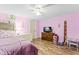 Comfortable bedroom featuring wood floors, a ceiling fan and natural light at 12526 Spottswood Dr, Riverview, FL 33579