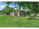 Well-maintained single-story home with a front porch, green lawn, and mature palm trees at 12526 Spottswood Dr, Riverview, FL 33579
