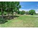 Expansive front yard with mature trees offering shade and character to the property at 12526 Spottswood Dr, Riverview, FL 33579