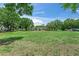 Expansive front yard view with a single-story house, green lawn, and beautiful mature trees at 12526 Spottswood Dr, Riverview, FL 33579