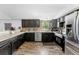 Updated kitchen with dark cabinetry, stainless steel appliances, and a mosaic backsplash at 12526 Spottswood Dr, Riverview, FL 33579