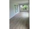 Bright room with wood floors, white trim, and large windows providing lots of natural light at 12526 Spottswood Dr, Riverview, FL 33579