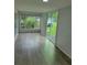 Living room with wood flooring, bright light from windows, and easy access to the outdoors at 12526 Spottswood Dr, Riverview, FL 33579