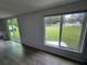 Bright room with wood floors, white trim, and a view of the backyard from large windows at 12526 Spottswood Dr, Riverview, FL 33579
