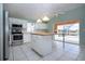 Bright kitchen featuring stainless steel appliances, a center island, and an adjacent pool view at 2211 N Creek Ct, Sun City Center, FL 33573