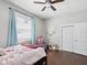 Bedroom features a ceiling fan, large window with blinds, and a closet at 8203 Interbay Blvd, Tampa, FL 33616